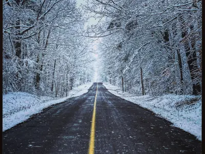 2021 3rd Place Photo - Looking down a winter road with snowy trees on both side, taken by Jesse Curley