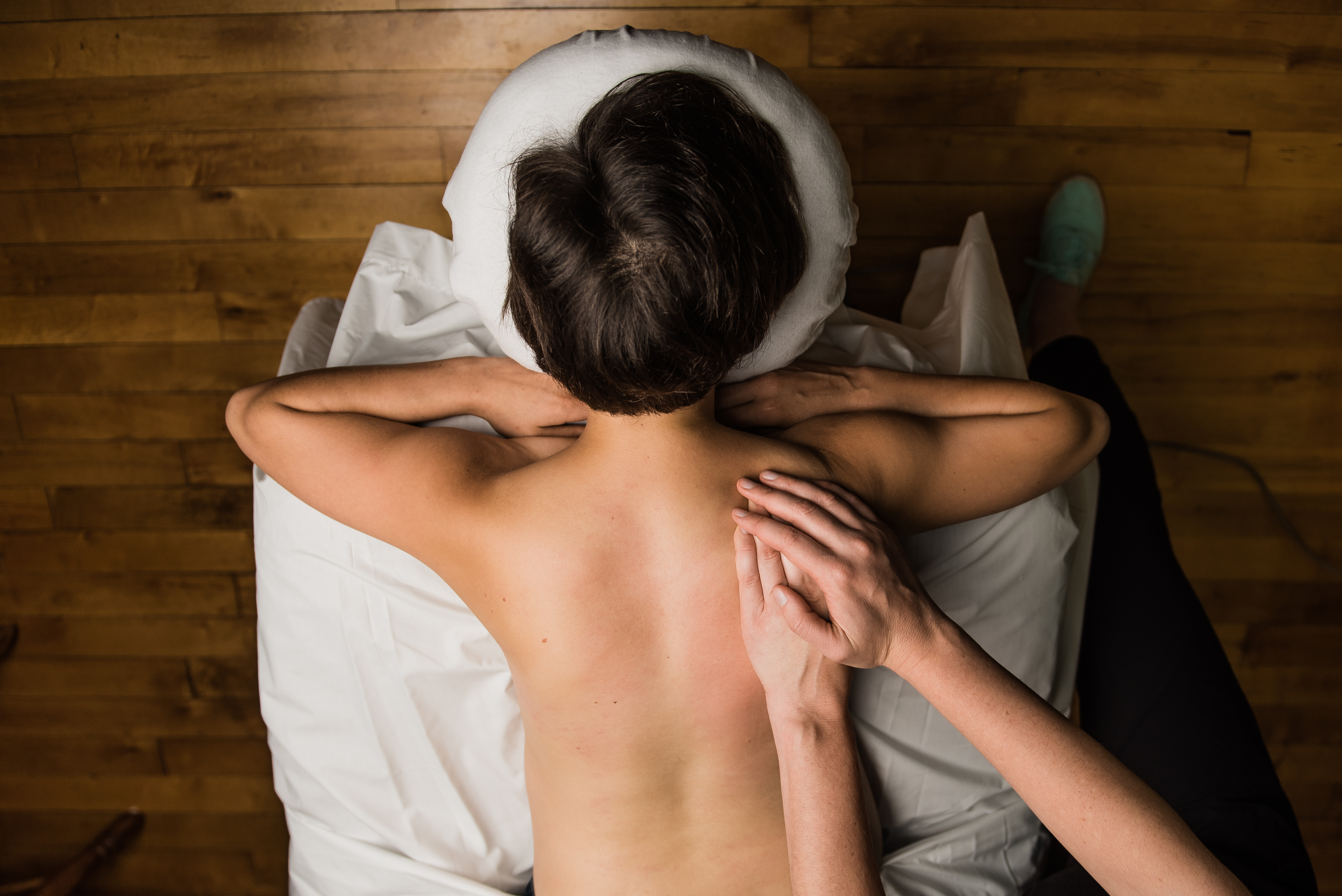 A woman lies on a massage table