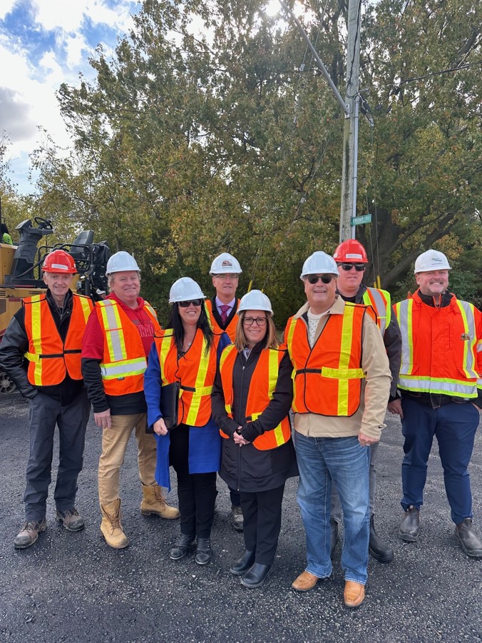 Council and staff standing on a newly paved gravel road.